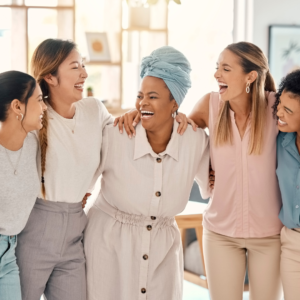 A racially diverse group of five women join together and laugh