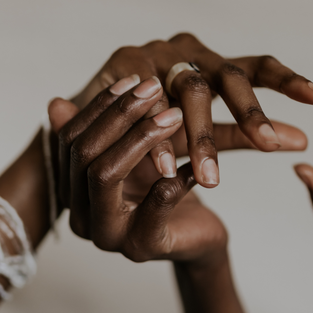 A pair of Black female hands touch